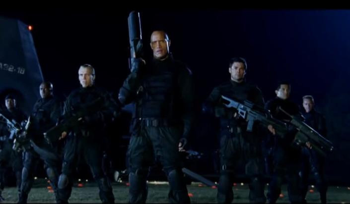 Dwayne Johnson and Karl Urban standing with the other marines ready for battle
