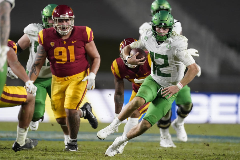 Oregon quarterback Tyler Shough (12) runs the ball during the second half of an NCAA college football game for the Pac-12 Conference championship against Southern California Friday, Dec 18, 2020, in Los Angeles. (AP Photo/Ashley Landis)