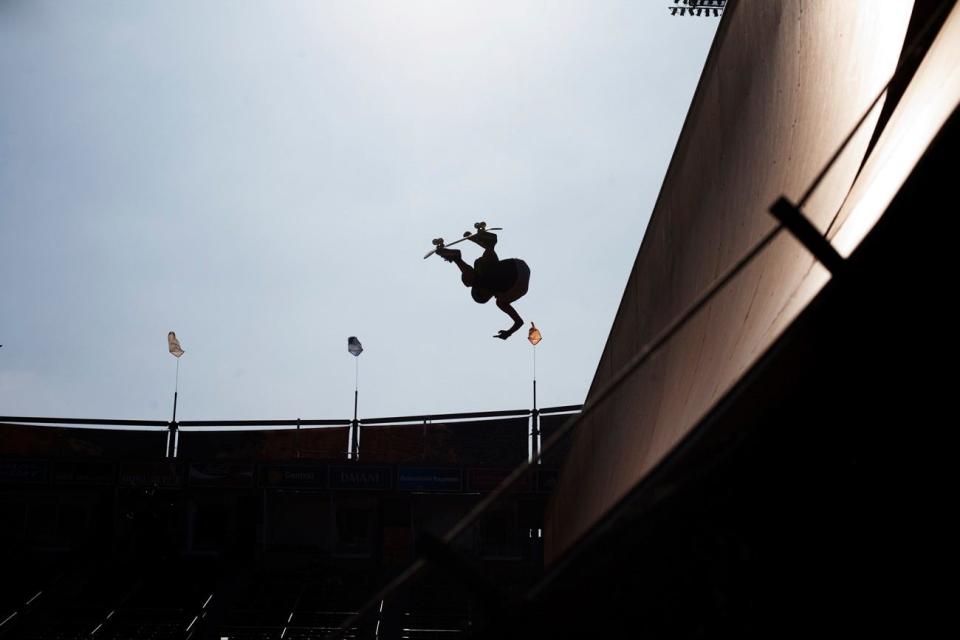 In this archived photo, a woman vert skateboarder flies through the air.