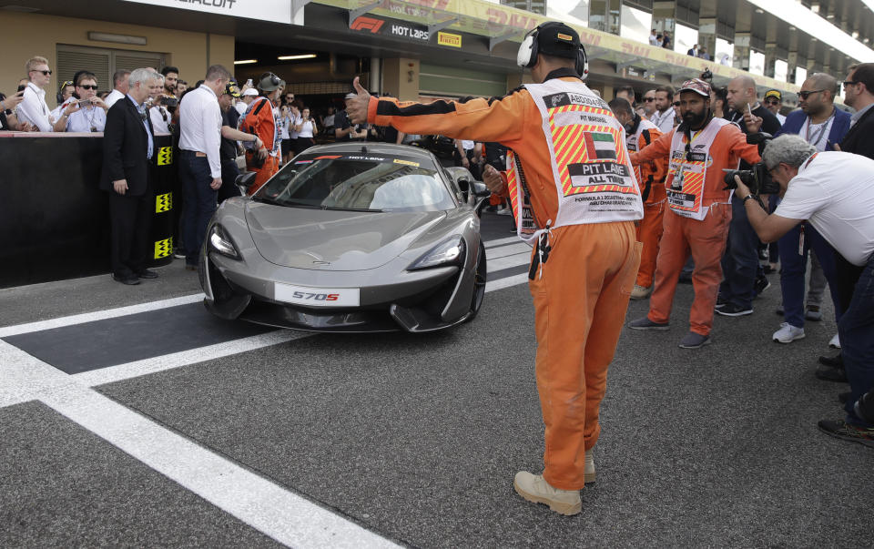 Mclaren driver Fernando Alonso of Spain, right, flanked by Nascar World champion Jimmie Johnson drive a McLaren 570S car at the Yas Marina racetrack in Abu Dhabi, United Arab Emirates, Saturday, Nov. 24, 2018. Seven-time NASCAR champion Jimmie Johnson and two-time Formula One champion Fernando Alonso drive Pirelli hot laps together around the Abu Dhabi F1 track on Saturday afternoon. (AP Photo/Luca Bruno)