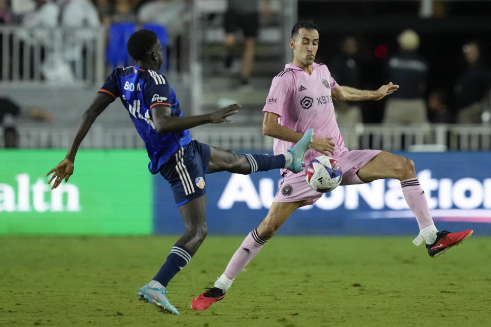 FC Cincinnati forward Dominique Badji, left, controls a ball while under pressure from Inter Miami midfielder Sergio Busquets, right, during the second half of an MLS soccer match, Saturday, Oct. 7, 2023, in Fort Lauderdale, Fla. (AP Photo/Rebecca Blackwell)