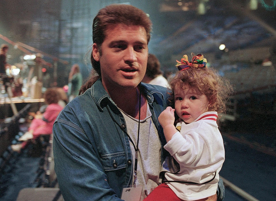 Celebrity holding a child backstage at an event