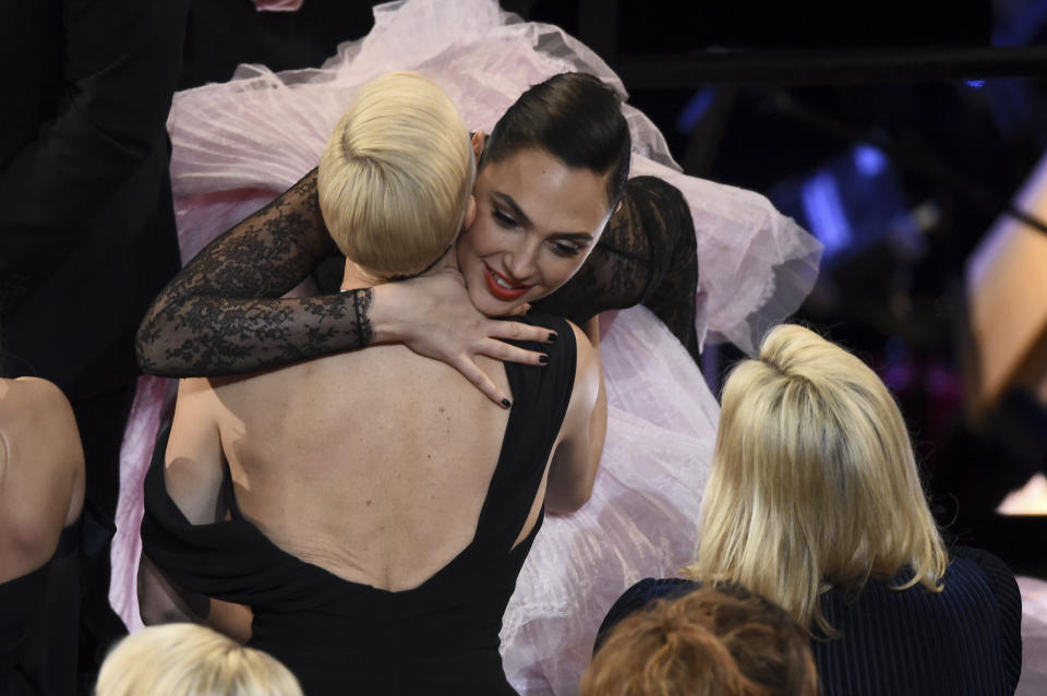 Charlize Theron, left, embraces Gal Gadot in the audience at the Oscars on Sunday, Feb. 9, 2020, at the Dolby Theatre in Los Angeles. (AP Photo/Chris Pizzello)