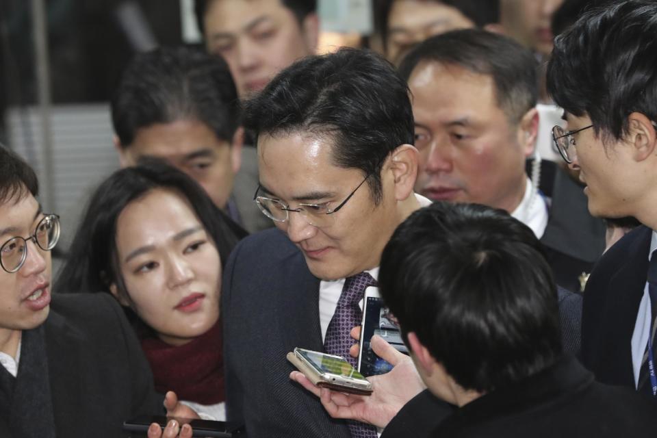 Lee Jae-yong, center, a vice chairman of Samsung Electronics Co. is questioned by reporters upon his arrival for the hearing at the Seoul Central District Court in Seoul, South Korea, Wednesday, Jan. 18, 2017. A South Korean court has begun reviewing the arrest of a Samsung Electronics vice chairman who faces allegations of bribery, embezzlement and perjury. (AP Photo/Lee Jin-man)