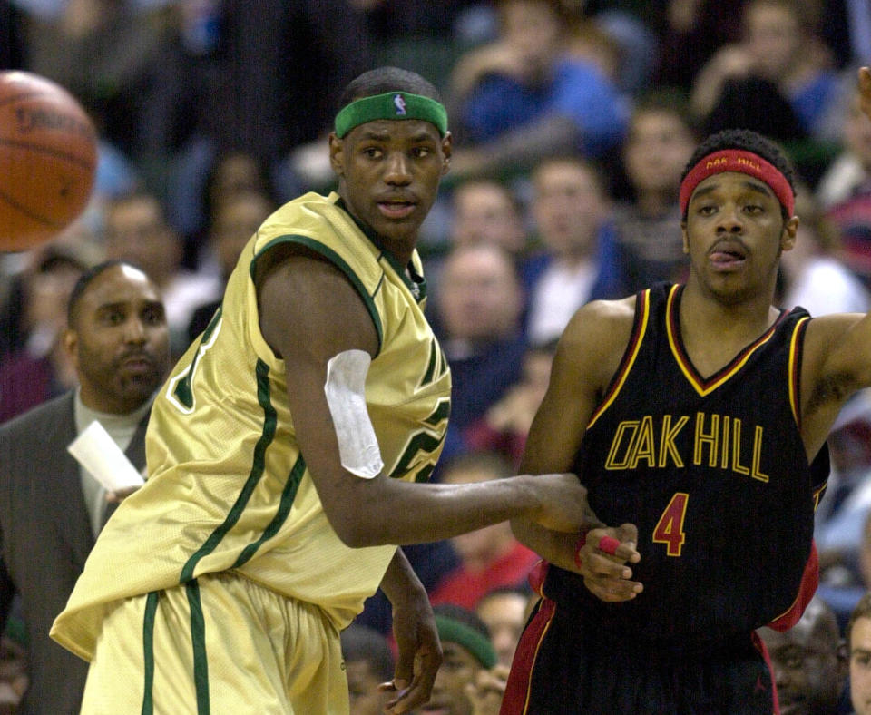 Akron St. Vincent-St. Mary's LeBron James, left, guards Isaiah Swann (4) of Virginia's Oak Hill Academy during the first half of a nationally televised high school game Thursday, Dec. 12, 2002, in Cleveland. James is perhaps the most talked about high school basketball player ever and the probable No. 1 overall pick in next year's NBA draft. (AP Photo/Mark Duncan)