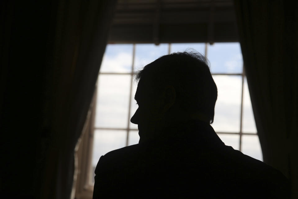 Massachusetts Governor Charlie Baker is seen in silhouette during an interview at the Massachusetts State House Tuesday Dec. 27, 2022, in Boston, Mass. (AP Photo/Reba Saldanha)