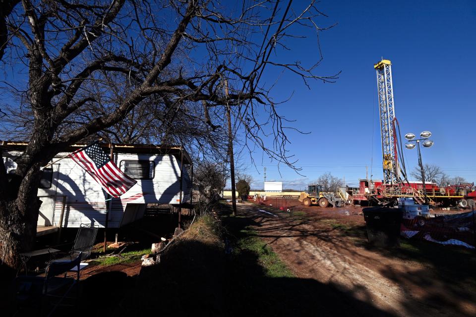 An American flag waves from a backyard across the alley from an oil drilling rig in the 2400 block of Burger St. Jan. 5.