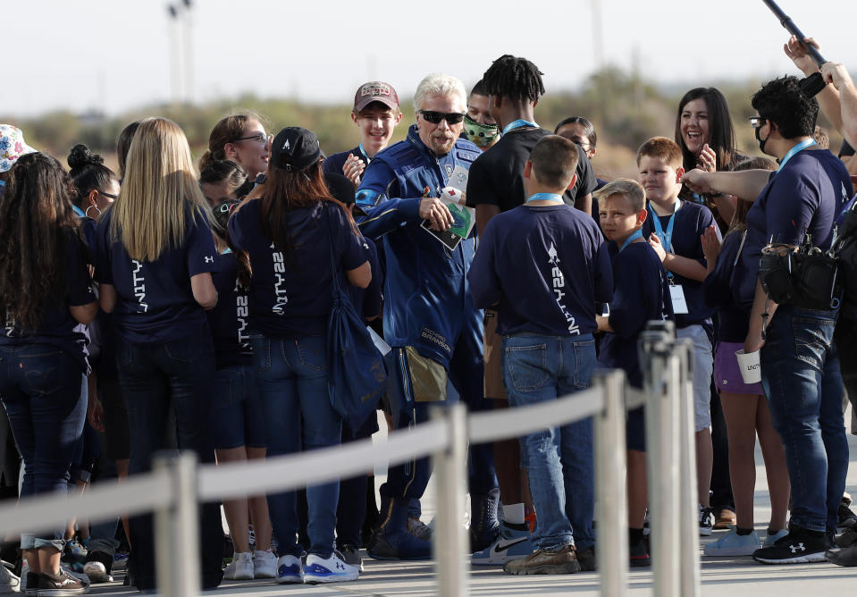 Virgin Galactic founder Richard Branson, center, is greeted by school children before heading to board the rocket plane that will fly him to the edge of space from Spaceport America near Truth or Consequences, New Mexico, Sunday, July 11, 2021. (AP Photo/Andres Leighton)