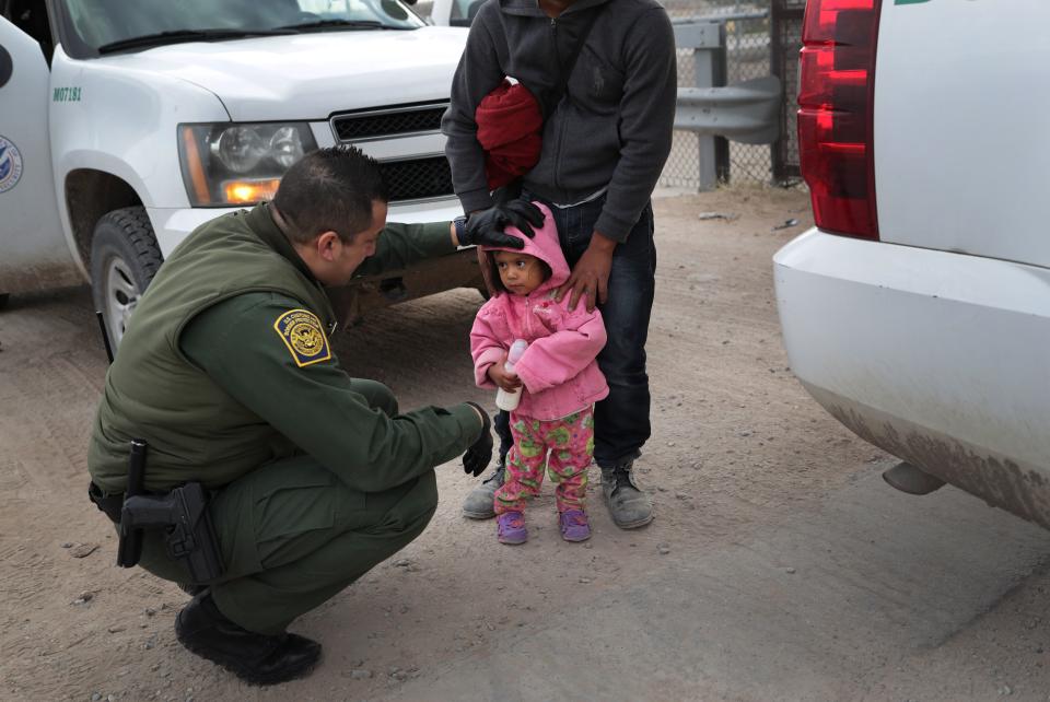 A Border Patrol agent speaks with Central American immigrants after they crossed the border from Mexico on on Feb. 1, 2019, in El Paso, Texas.