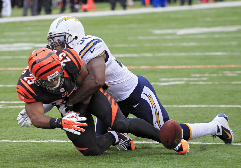 Cincinnati Bengals running back Giovani Bernard (25) fumbles as he is hit by San Diego Chargers linebacker Donald Butler in the first half of an NFL wild-card playoff football game on Sunday, Jan. 5, 2014, in Cincinnati. (AP Photo/Tom Uhlman)