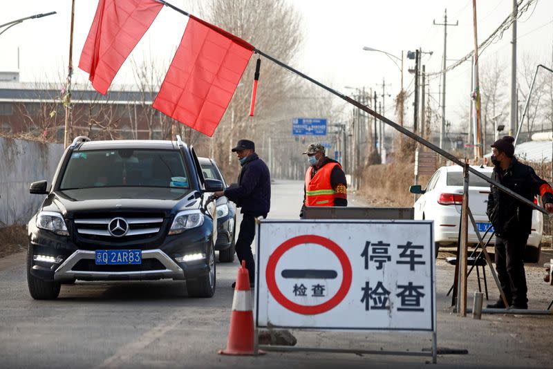 Volunteers stop a car at a checkpoint on a road leading into their village on the outskirts of Beijing