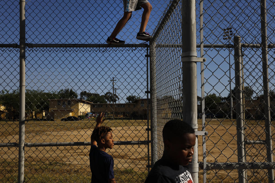 Three boys pass time in an empty playground at the Nickerson Gardens housing project in the Watts neighborhood of Los Angeles, Wednesday, June 10, 2020. Watts has long been associated with deadly and destructive rioting in 1965. This summer when widespread mostly peaceful protests for racial justice across the U.S. have been accompanied at times by vandalism and other crimes, Watts has been peaceful. One lawmaker says the residents learned long ago that it didn't pay to burn their own neighborhood. (AP Photo/Jae C. Hong)