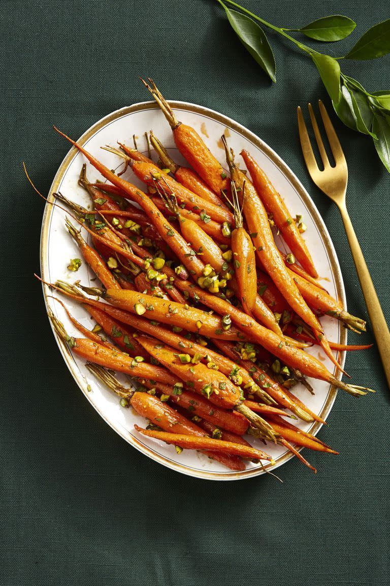 whole, spiced, roasted carrots on a white plate
