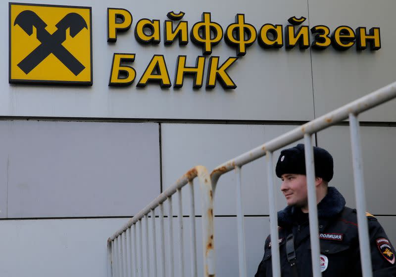 FILE PHOTO: Russian police officer stands in front of branch of Raiffeisen Bank in Moscow