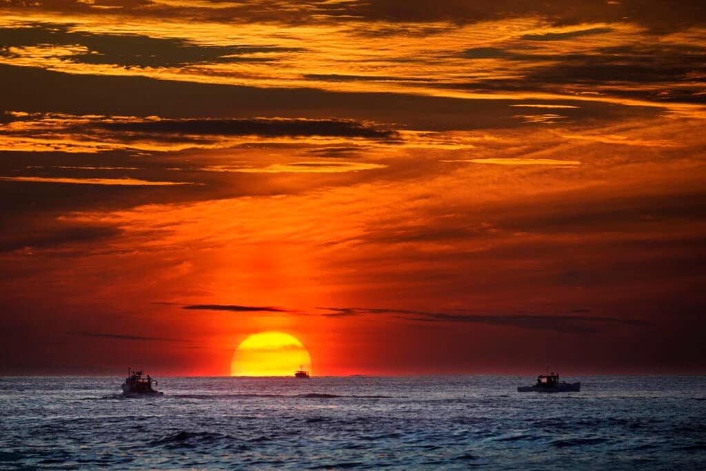 Lobster fishermen are already at work as the sun rises over the Atlantic Ocean, Thursday, Sept. 8, 2022, off of Kennebunkport, Maine. (AP Phot6o/Robert F. Bukaty)