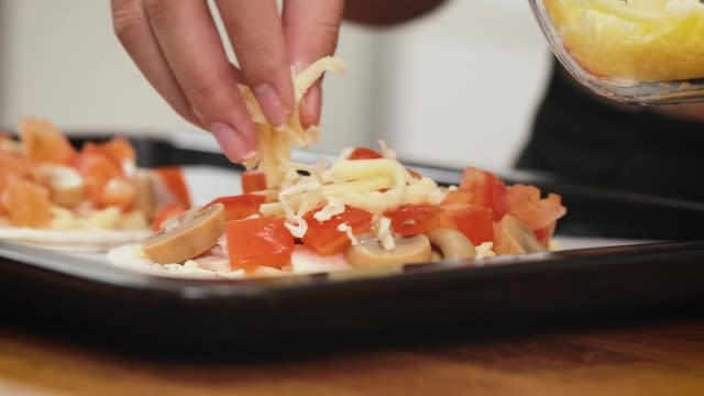 sprinkling prata pizza with mozzerella cheese