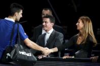 World number one Novak Djokovic of Serbia (L) shakes hands with French Prime Minister Manuel Valls (C) and his wife Anne Gravoin (R) after he defeated Stan Wawrinka of Switzerland in their men's singles semi-final tennis match at the Paris Masters tennis tournament at the Bercy sports hall in Paris, France, November 7, 2015. REUTERS/Charles Platiau