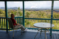 <p>Mark Clawson, 64, sits on his porch on the outskirts of Pahoa above recent lava flows during ongoing eruptions of the Kilauea Volcano in Hawaii, June 6, 2018. (Photo: Terray Sylvester/Reuters) </p>