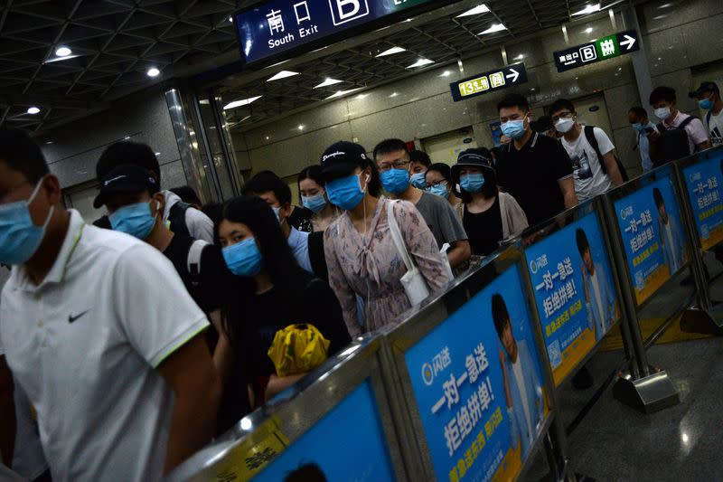 People wearing face masks commute inside a subway station during morning rush hour, following new cases of coronavirus disease (COVID-19) infections in Beijing