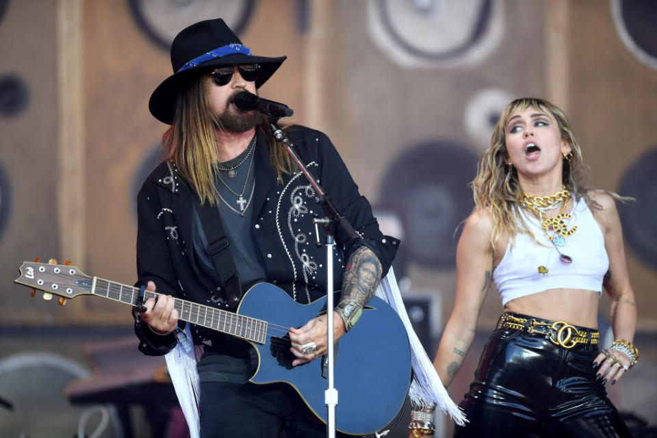 miley performing on stage with her dad