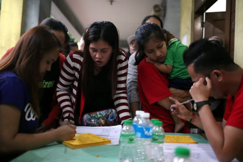 Families register their names at the Delpan Evacuation Center after Typhoon Kammuri hit Metro Manila,