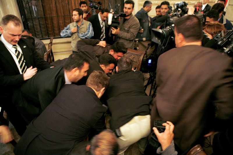 FILE PHOTO: Security tackle a man who threw a shoe at U.S. President Bush during a joint statement with Iraqi PM Nouri al-Maliki in Baghdad