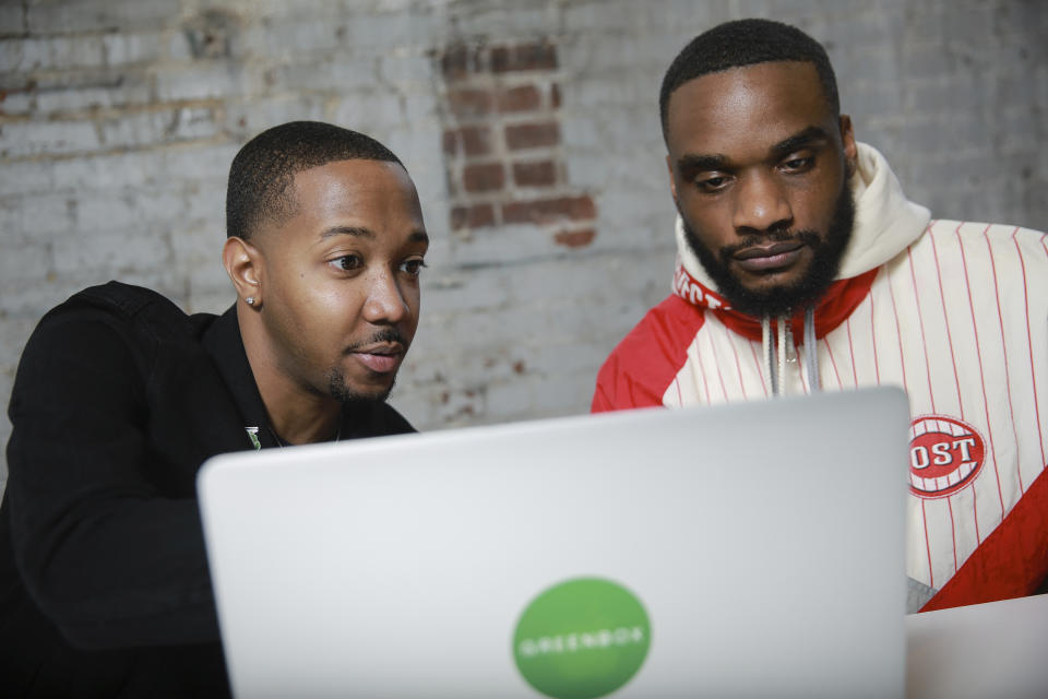 In this April 26, 2019 photo, business partners Ethan Jackson, left, and Andrew Farrior check emails before a meeting in Atlanta, Ga. As an aspiring marijuana businessman in New York, Farrior is following the marijuana legalization debate and its talk of social equity. He and he and co-founder Jackson are plowing ahead with plans to launch Greenbox.NYC as a subscription and delivery business for hemp and other legal cannabis-related products. (AP Photo/Elijah Nouvelage)