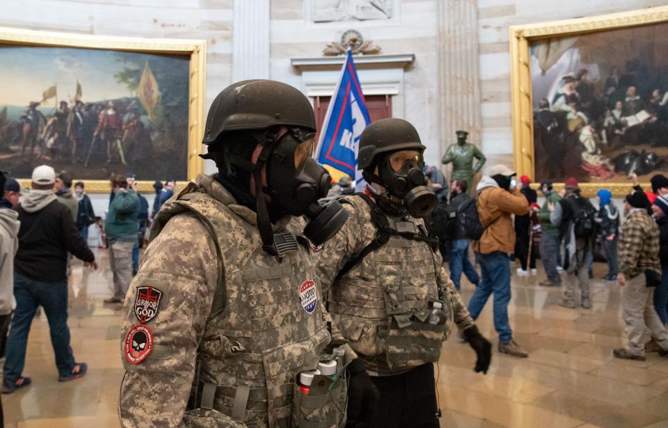 (FILES) Supporters of US President Donald Trump wear gas masks and military-style apparel as they walk around inside the Rotunda after breaching the US Capitol in Washington, DC, January 6, 2021. - Demonstrators breeched security and entered the Capitol as Congress debated the 2020 presidential election Electoral Vote Certification. (Photo by SAUL LOEB / AFP) (Photo by SAUL LOEB/AFP via Getty Images)