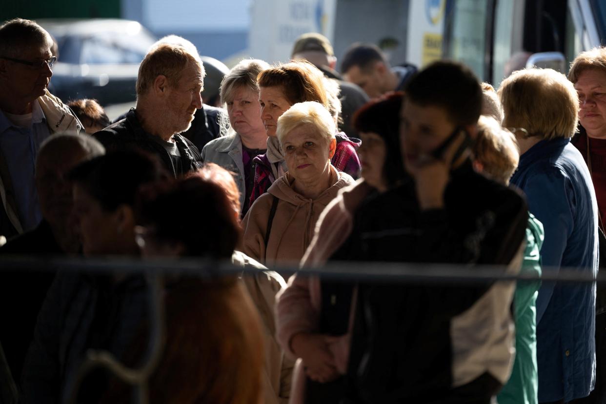 Local residents are seen a during an evacuation effort at a bus station in the outskirts of Kherson (REUTERS)