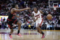 Miami Heat guard Delon Wright (4) drives to the basket against Chicago Bulls guard Ayo Dosunmu (12) during the first half of an NBA basketball play-in tournament game, Friday, April 19, 2024, in Miami. (AP Photo/Wilfredo Lee)