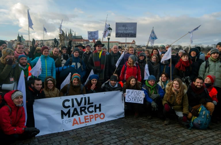 People pose on the Charles bridge during a solidarity civil march for Aleppo on January 15, 2017 in Prague