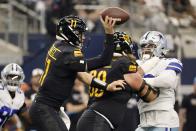 Washington Commanders quarterback Carson Wentz (11) throws a pass under pressure in the first half of a NFL football game against the Dallas Cowboys in Arlington, Texas, Sunday, Oct. 2, 2022. (AP Photo/Ron Jenkins)