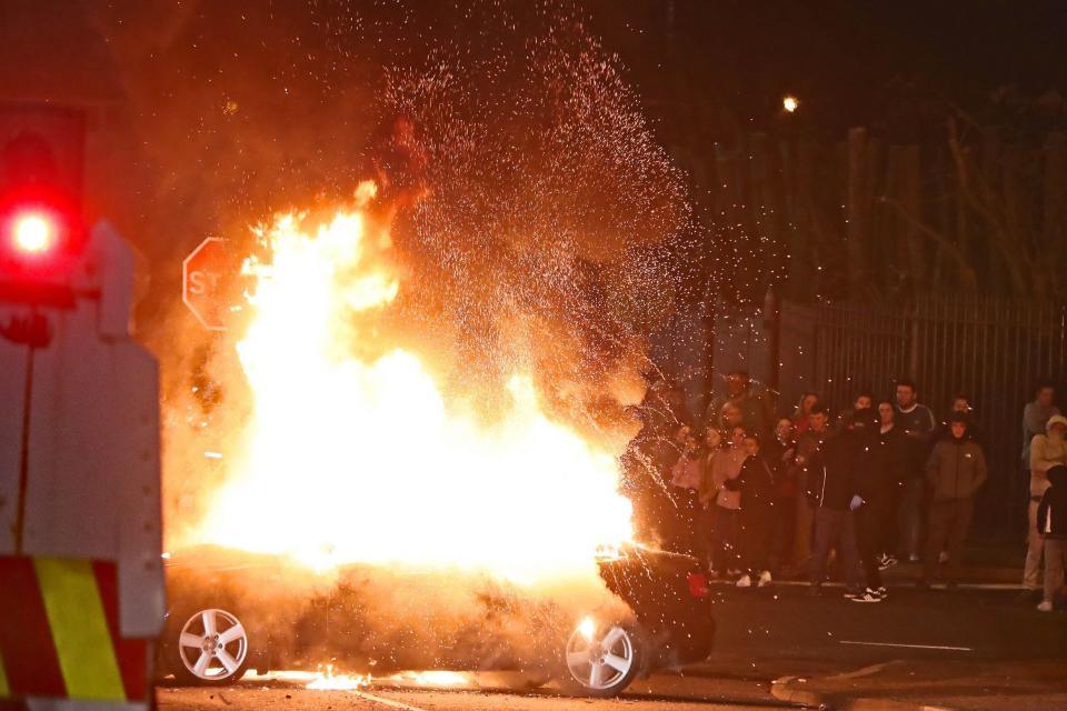 A hijacked car explodes after being set on fire in Creggan. (PA)