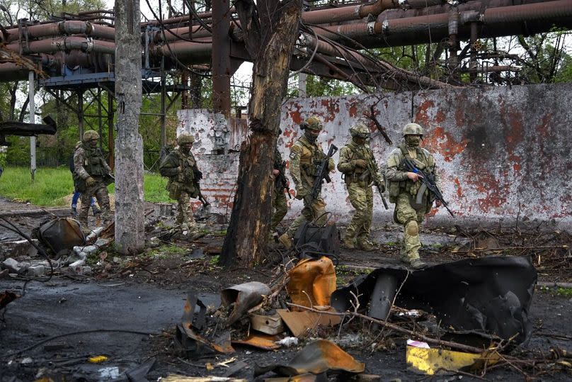 Russian troops walk in a destroyed part of the Illich Iron & Steel Works Metallurgical Plant in Mariupol, in territory under the government of the Donetsk.