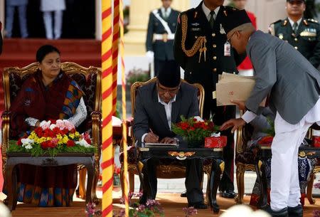 Newly elected Nepalese Prime Minister Pushpa Kamal Dahal, also known as Prachanda, sign the oath papers after administrating the oath of office in the presence of President Bidhya Devi Bhandari (L) at the presidential building "Shital Niwas" in Kathmandu, Nepal August 4, 2016. REUTERS/Navesh Chitrakar