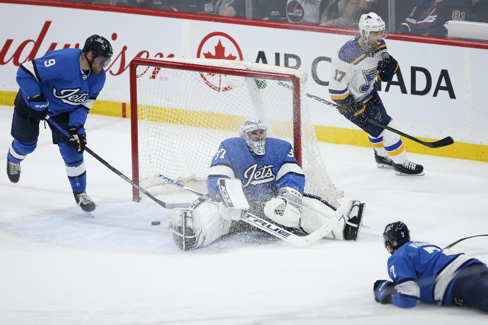 St. Louis Blues' Jaden Schwartz (17) celebrates a goal by Brayden Schenn against Winnipeg Jets goaltender Connor Hellebuyck (37) as Andrew Copp (9) and Dmitry Kulikov (7) defend during the third period of an NHL hockey game Saturday, Feb. 1, 2020, in Winnipeg, Manitoba. (John Woods/The Canadian Press via AP)