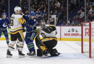 Vancouver Canucks' Tanner Pearson (70) and Pittsburgh Penguins' Chad Ruhwedel (2) watch as Vancouver's Vasily Podkolzin, not seen, scores against Pittsburgh goalie Tristan Jarry, right, during the second period of an NHL hockey game Saturday, Dec. 4, 2021, in Vancouver, British Columbia. (Darryl Dyck/The Canadian Press via AP)