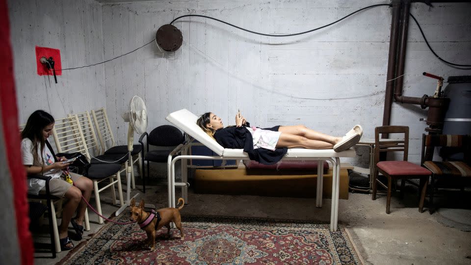 Israelis take cover in a bomb shelter as rockets are launched from the Gaza Strip. - Hadas Parush/Reuters