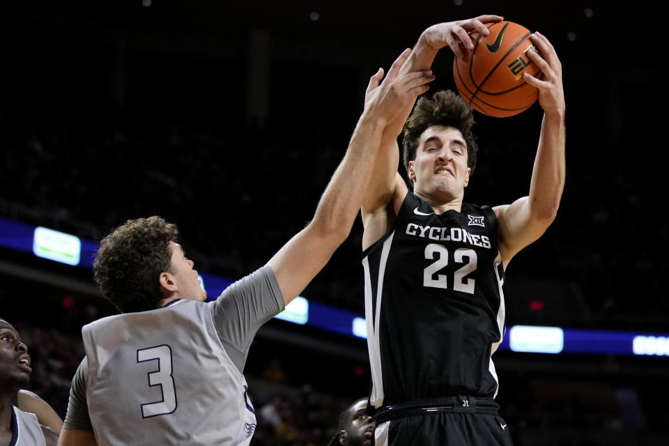 Iowa State forward Milan Momcilovic (22) grabs a rebound over New Hampshire forward Jaxson Baker (3) during the second half of an NCAA college basketball game, Sunday, Dec. 31, 2023, in Ames, Iowa. Iowa State won 85-70. (AP Photo/Charlie Neibergall)