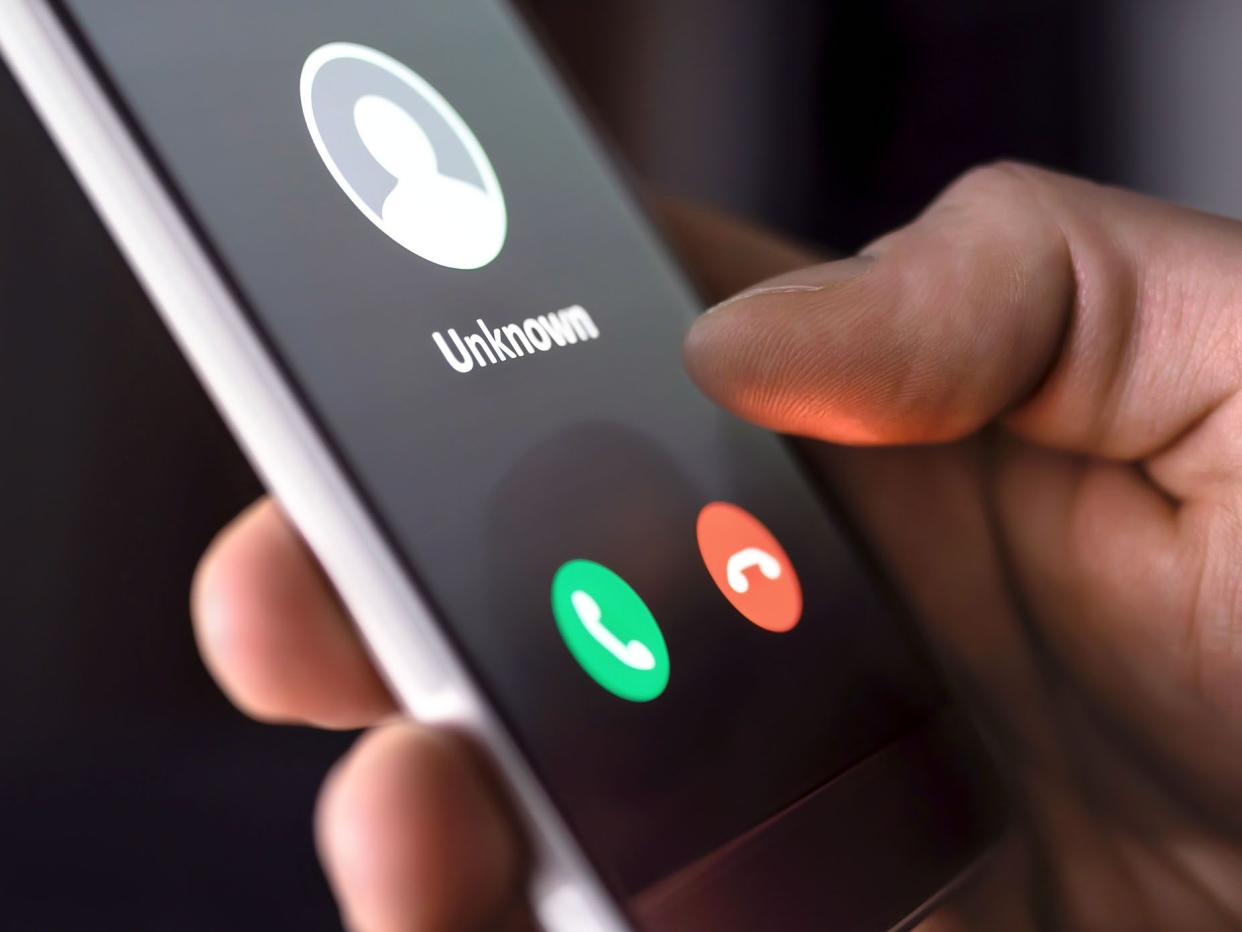 Phone call from unknown number late at night. Scam, fraud or phishing with smartphone concept. Prank caller, scammer or stranger. Man answering to incoming call. Hoax person with fake identity.