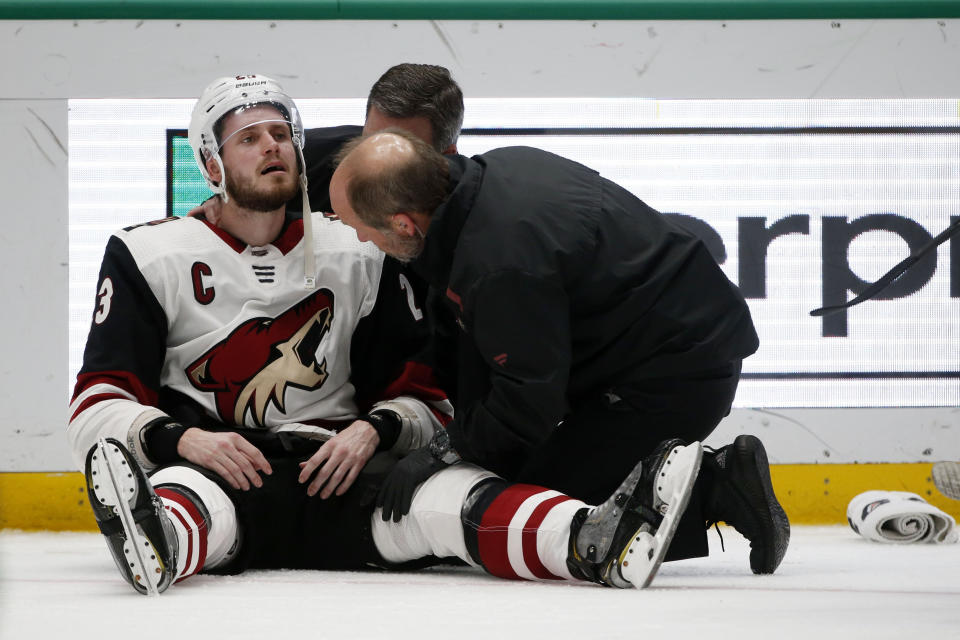 Arizona Coyotes defenseman Oliver Ekman-Larsson (23) is examined by trainers after a hit by Dallas Stars left wing Jamie Benn that resulted in a penalty against Benn, during the second period of an NHL hockey game in Dallas, Wednesday, Feb. 19, 2019. (AP Photo/Michael Ainsworth)