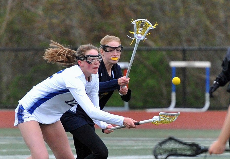 Norwell's Charlise Cox, left, grabs a loose ball as Notre Dame Academy's Reilly Walsh, right, moves in during girls lacrosse at Norwell High School, Thursday, May 4, 2023.