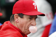 Philadelphia Phillies interim manager Rob Thomson manager blows a bubble in the dugout before the beginning of a baseball game against the Washington Nationals, Sunday, Oct. 2, 2022, in Washington. (AP Photo/Luis M. Alvarez)