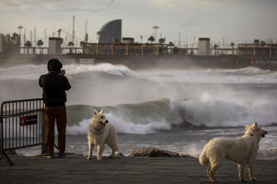 A man photographs the Mediterranean sea during strong winds in Barcelona, Spain, Monday, Jan. 20, 2020. Two people have died as storms carrying heavy snowfalls and gale-force winds lashed many parts of Spain on Monday. The storm has forced the closure of Alicante airport and some 30 roads in eastern region. Six provinces are on top alert. (AP Photo/Emilio Morenatti)