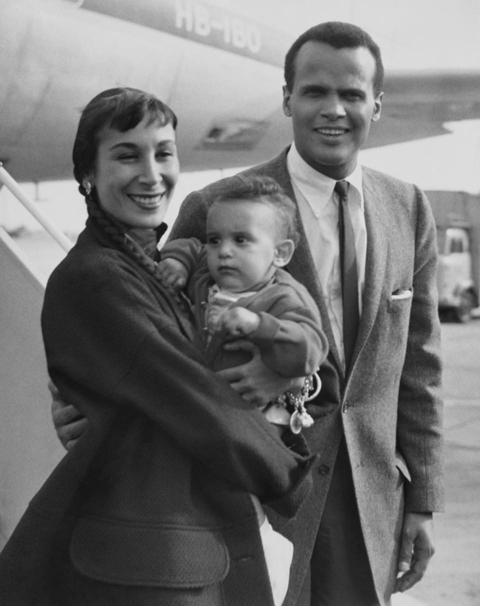 American dancer Julie Belafonte holding her son, David, with husband, American singer-songwriter and civil rights activist Harry Belafonte at an unspecified airport in London, England, 31st July 1958. Harry Belafonte is in London to perform a series of shows. (Photo by Express/Archive Photos/Hulton Archive/Getty Images)