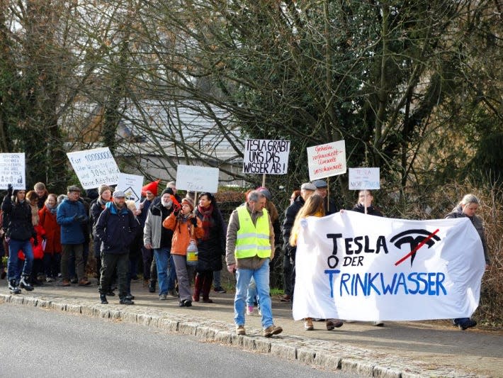 Demonstrators hold anti-Tesla posters during a protest against plans by U.S. electric vehicle pioneer Tesla to build its first European factory and design center in Gruenheide near Berlin, Germany January 18, 2020. REUTERS/Pawel Kopczynski
