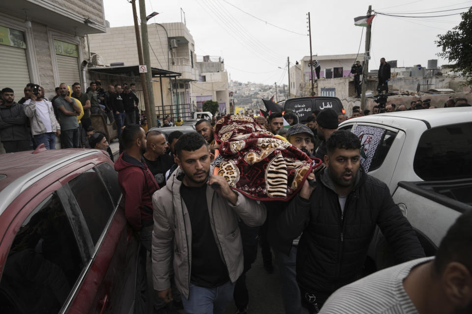 Mourners carry the body of Palestinian Fulla al-Masalmeh,15, during her funeral in the West Bank village of Beit Awwa, Tuesday, Nov. 15, 2022. The Palestinian Health Ministry says Israeli forces shot and killed a 15-year-old Palestinian girl during a pre-dawn raid in the occupied West Bank. The circumstances surrounding the death of the teenage girl in the city of Beitunia in the central West Bank, identified by Palestinian health officials as Fulla al-Masalmeh, were not fully clear. The Israeli military said soldiers opened fire on a vehicle that was accelerating toward them after they signaled for it to stop. The military said it was investigating, and declined to comment further. (AP Photo/Mahmoud Illean)