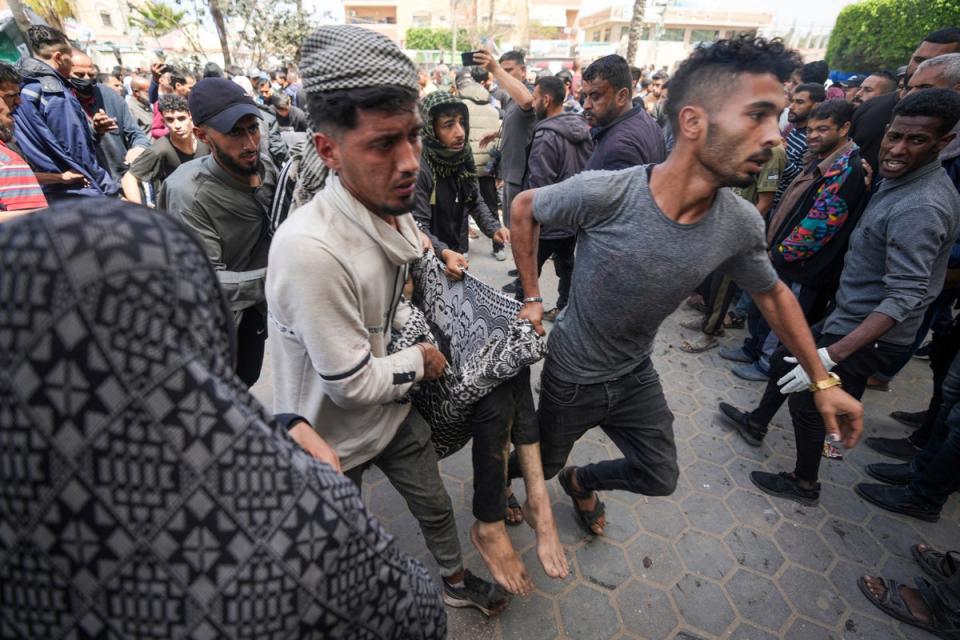 Palestinians carry a wounded person following an Israeli airstrike near the Al Aqsa hospital in Deir al Bala (Copyright 2024 The Associated Press. All rights reserved.)