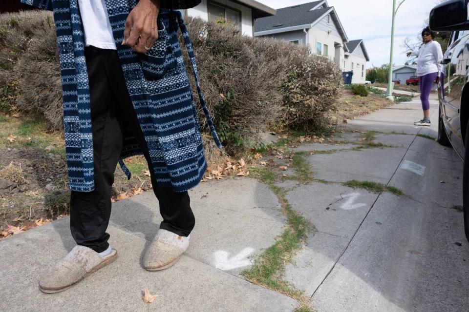 Charles, left, and Ola Gipson stand in November near the white arrows a Sacramento city inspector painted on the portions of the sidewalk that the city wanted replaced. The Gipsons hired a private contractor to save some money on the proposed $10,383 bill.