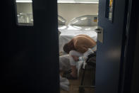 A patient infected with Coronavirus rests in a chair inside an isolated room at the COVID-19 ward of a public hospital in Barcelona, Spain, Nov. 18, 2020. The image was part of a series by Associated Press photographer Emilio Morenatti that won the 2021 Pulitzer Prize for feature photography. (AP Photo/Emilio Morenatti)